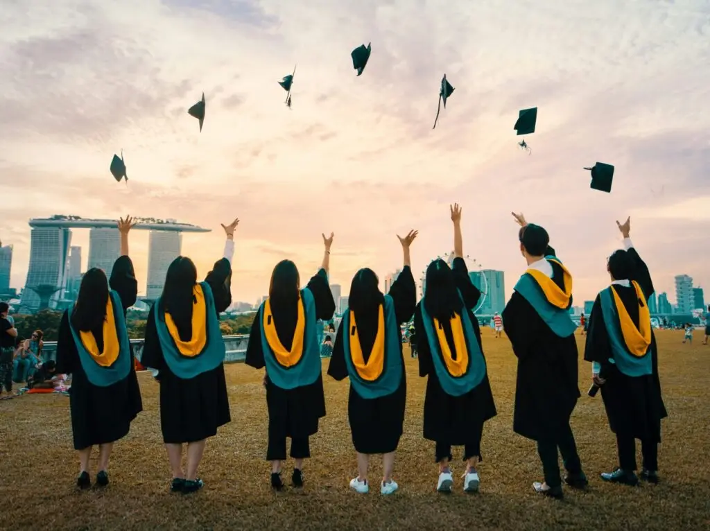 a group of people throwing their graduation caps in the air.